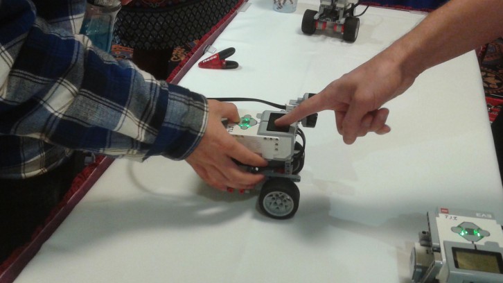 A Nova Scotia Community College recruit shows a student how to use a Lego robot. 