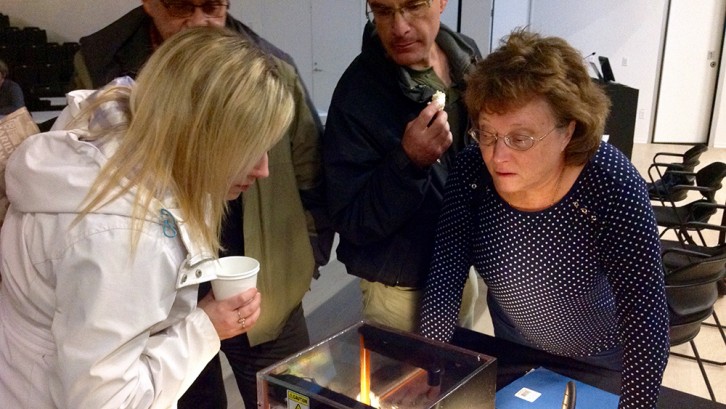 Guests at the science talk in Paul O'Regan Hall watch as a glass box fills with radon gas.