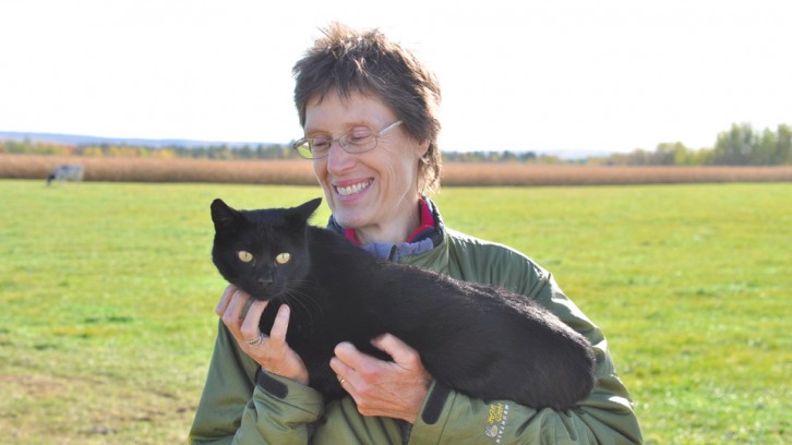 Irma Langelaan cuddles with a barn cat on her dairy farm in Aylesford, N.S.