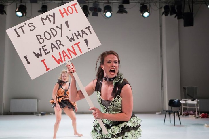 Erin Harty holds a protest sign during her performance in Juxtapose