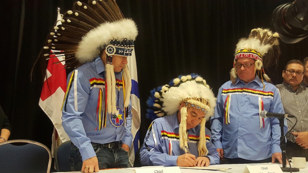 Glooscap First Nation Chief Sidney Peters (middle) signs the registry.