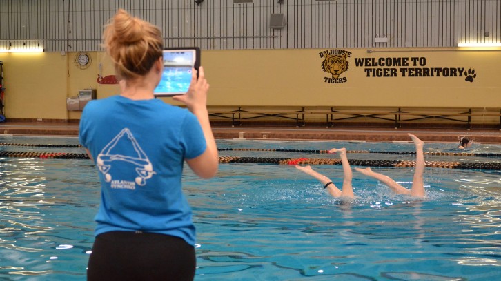Ally Merrill uses an iPad to record video of her swimmers.