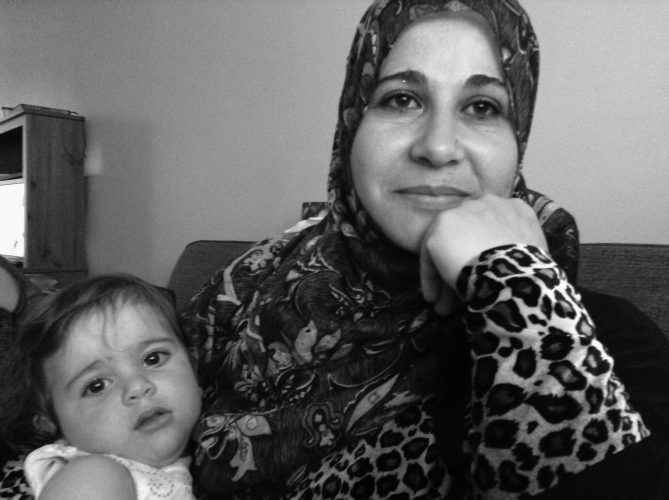 Rania AlMethyb holds her youngest daughter, Raneem, at their home in New Glasgow.