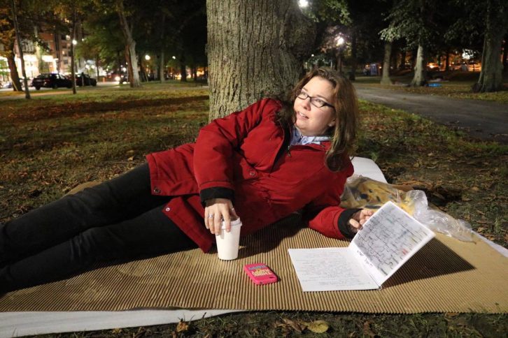 Tracey Roren rests on her cardboard at the Sleep Out with her reflective journal.