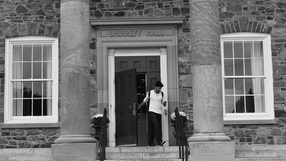 A student leaves out the front door of Shirreff Hall.
