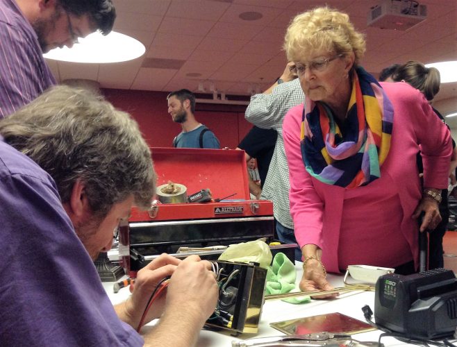 Peter Spierenburg with Halifax Maker Space helps Rose Marie Mahr fix her lamp. Halifax Maker Space is a group that repurposes materials in various ways.