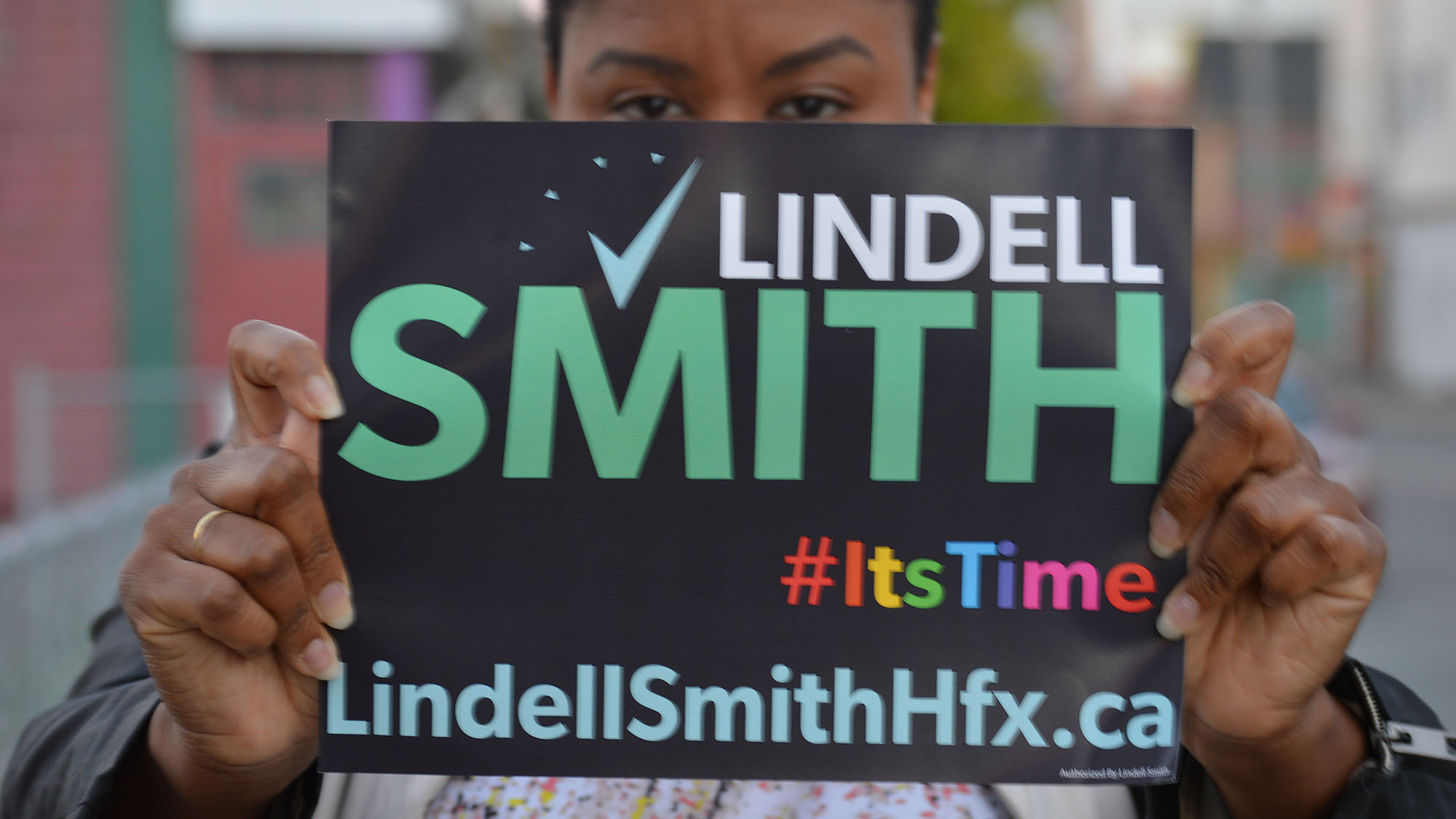 LaMeia Reddick, a volunteer in Lindell Smith’s campaign holds up one of his many campaign signs. 