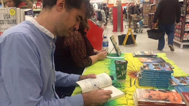 Jon Tattrie signs copies of his books Limerence and Day Trips from Halifax in the book section at a Halifax grocery store. 