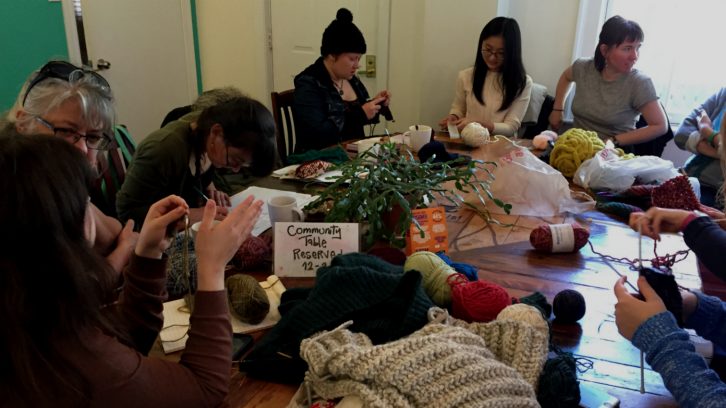Jessica Melindy (far-right) talks with participants at her monthly knitting group In Gauge in a cafe in Halifax.