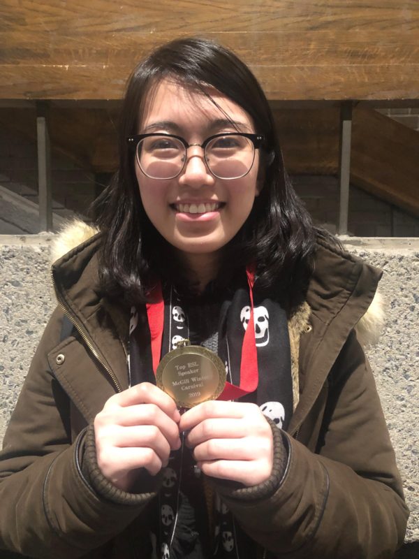 Yankun Li holding a medal she won at a McGill debate tournament