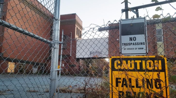 Bloomfield Centre's building, showing a bent fence and 'no trespassing' signs.