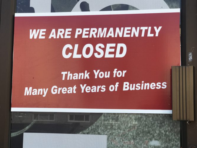 Photo of a sign on a door that says permanently closed for business