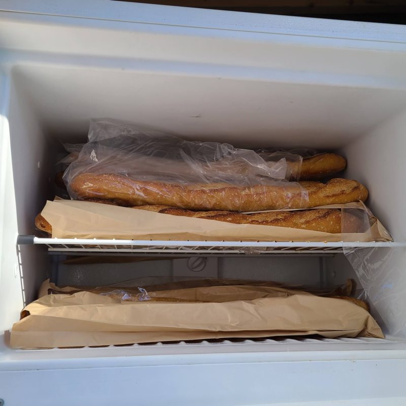 Several baguettes are seen inside of the freezer portion of the Halifax Community Fridge.