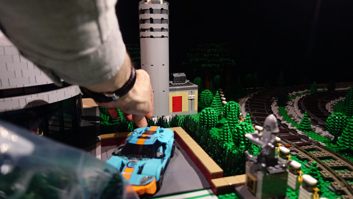 A man puts plastic plants into Lego buildings