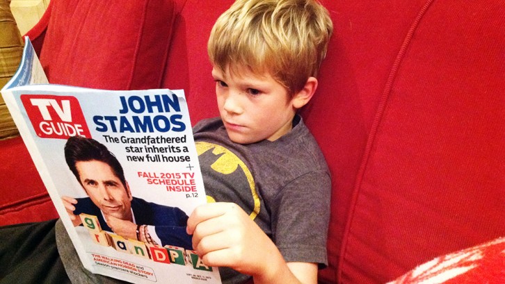 Vaughan, 6, flips through the TV guide for programmes of interest to him. 