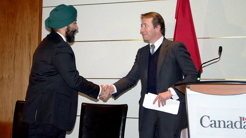 Economic Development minister Bains shakes hands with Treasury Board president Scott Brison before announcing the new investments.