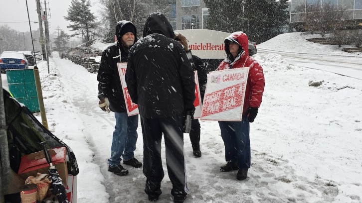 Striking employees walk the picket line outside the entrance to the Chronicle Herald on Joseph Howe Drive.