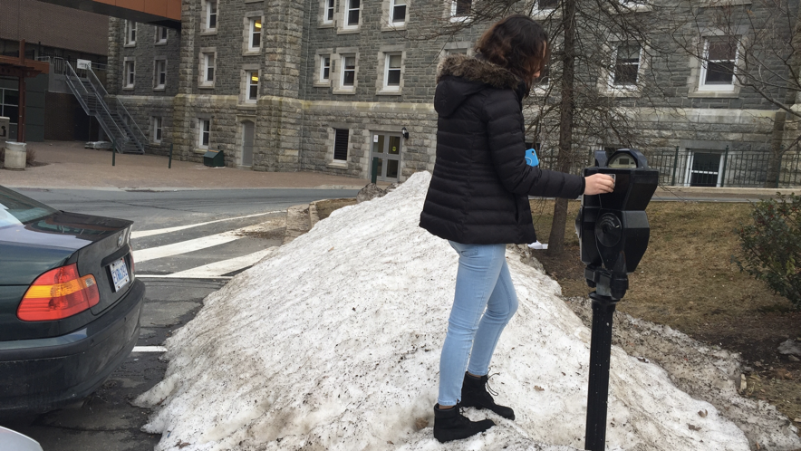 A student puts money in a meter at Saint Mary’s University