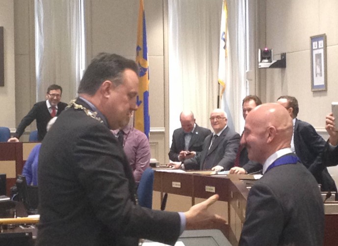Mayor Mike Savage and Tony Mancini shake hands after Mancini has taken his oath.