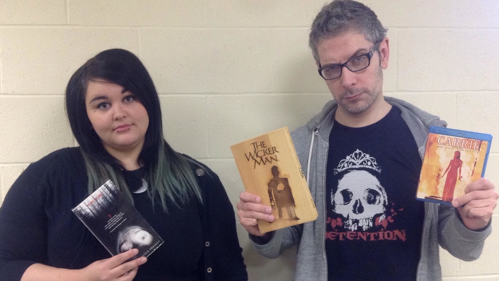 Thrillema volunteers Jess Smallwood and Mark Palermo hold up copies of their favorite horror movies.