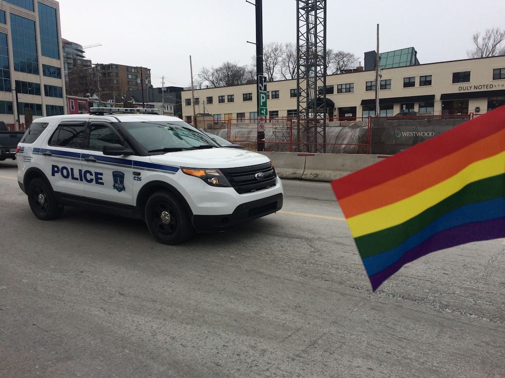 Photo Illustration. Pride flag held next to HRP car.