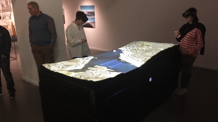 Two gallery visitors use augmented reality headsets to explore the site of the Halifax Explosion.