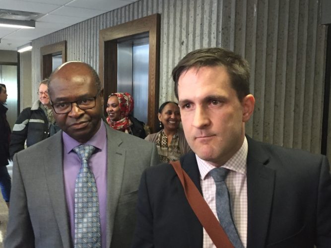 Abdoul Abdi’s attorney Benjamin Perryman (right) speaks to reporters outside of the courtroom. 