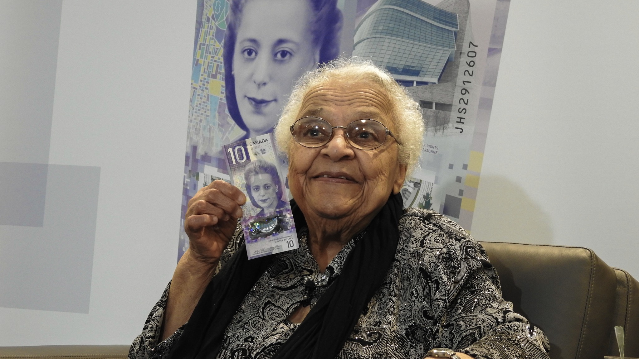 Wanda Robson poses with the $10 bill featuring a portrait of her sister.