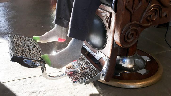 Eleven-year-old Josiah Brown's feet just reach the chrome foot pedal of Jack Desmond's barber chair.