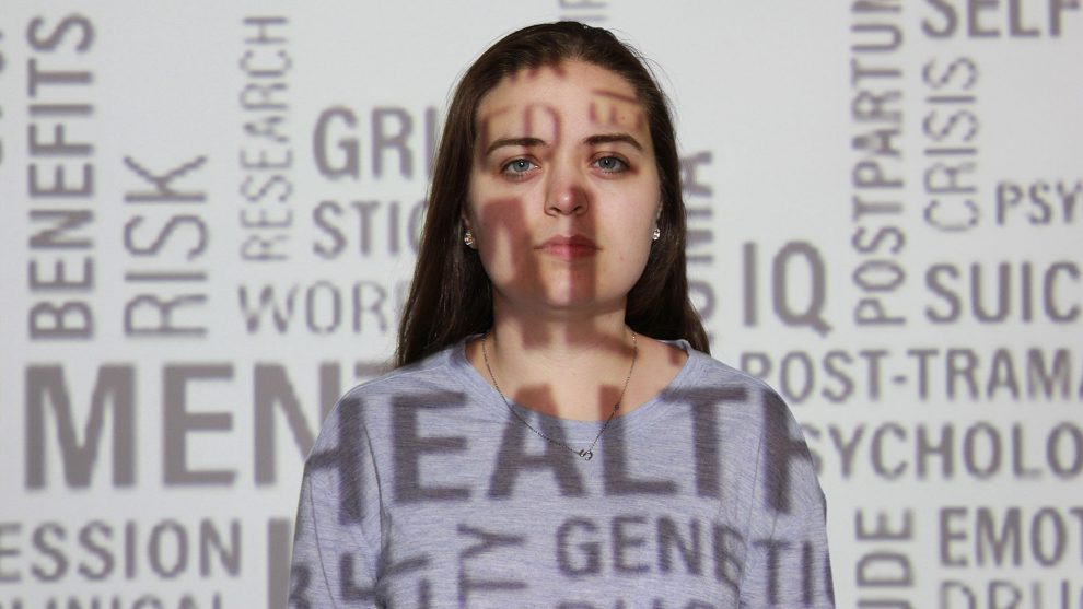 A model is projected with words related to mental health. 