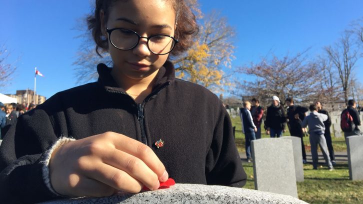 Carina Rolfe, 14, lays a poppy on Pte. Wallace Lamrock's grave at Fort Massey Cemetery.