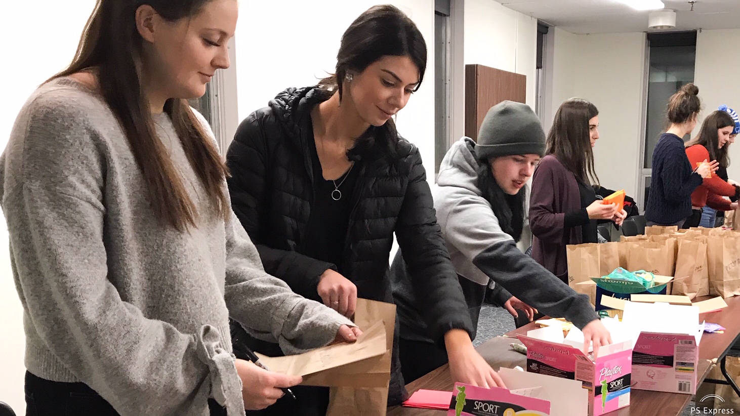 Volunteers pack menstrual products in bags for Halifax shelters.