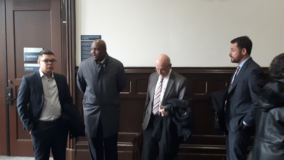 Const. George Edward Farmer, second from the left, stands with his legal team, right and a supporter, left, before entering the courtroom Jan. 18, 2019