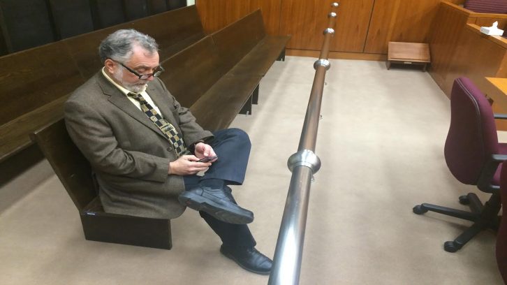 John Piccolo, the director of communications for the Nova Scotia Judiciary, reads from his Blackberry in an empty courtroom at the Halifax Law Courts.