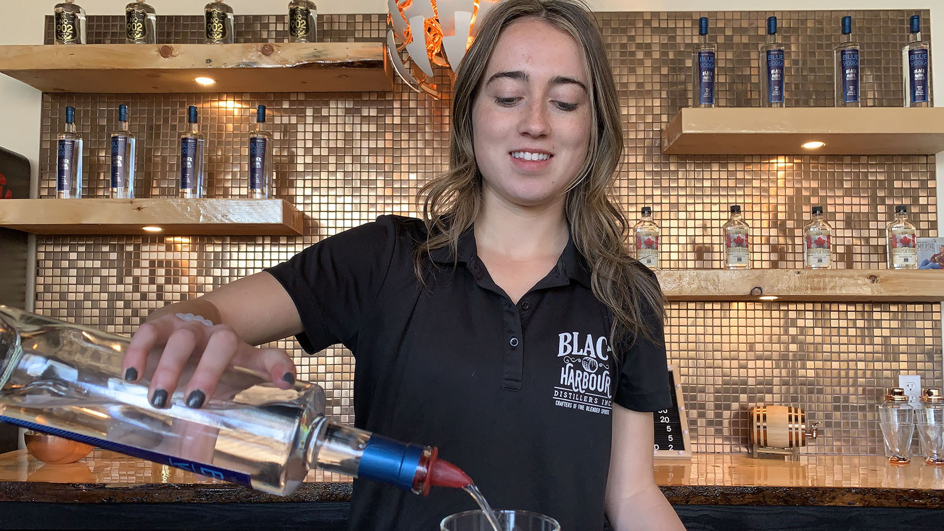 Jaime Landry pouring a drink at her bar in Fox Point, N.S. 