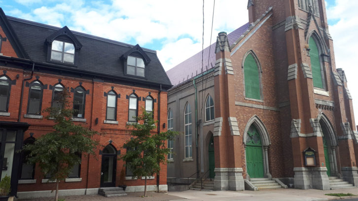The approved building is to be constructed behind the old rectory (left), adjacent to St. Patrick’s Church (right).