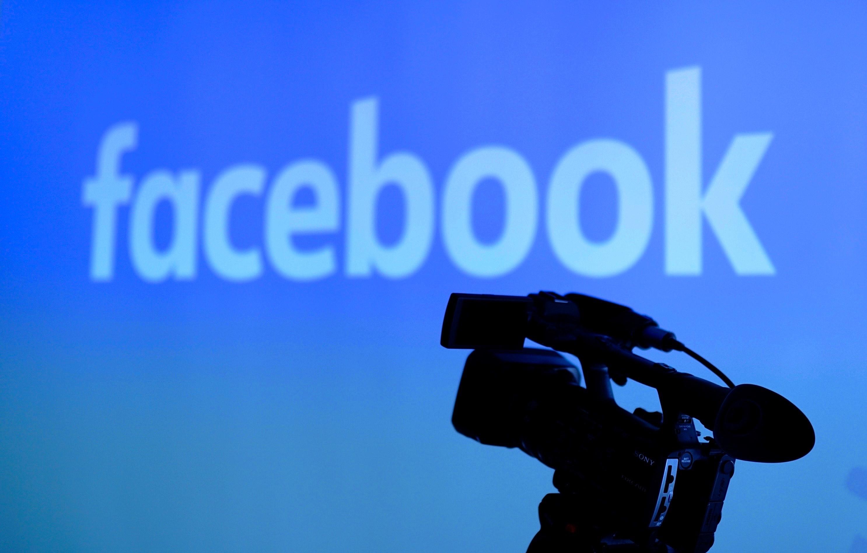 The Facebook logo is seen behind a video camera.