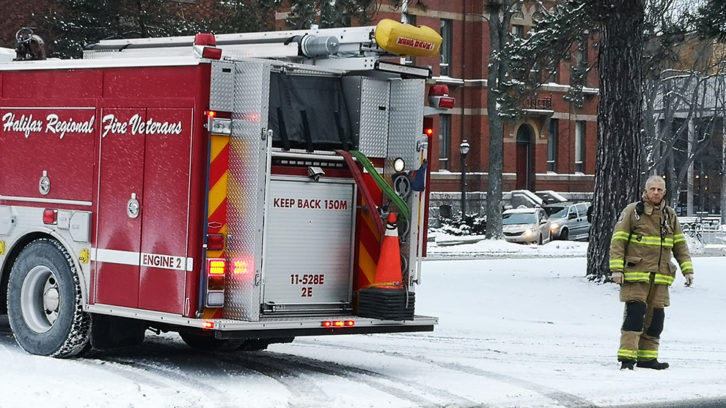 A firefighter standing next to a fire truck on University Avenue, Halifax.