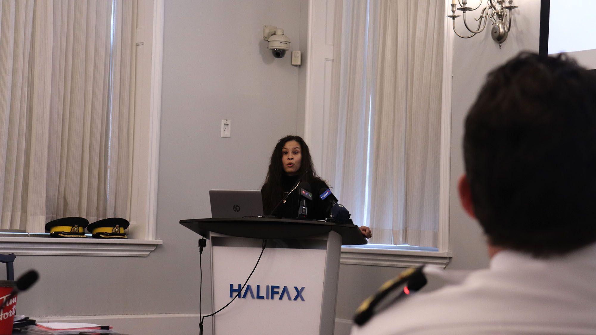 HRP Chief Dan Kinsella (foreground) watches Halifax activist El Jones speak at the board of police commissioners meeting on Monday. Jones said the police budget should be frozen until HRP takes better action on racial profiling.