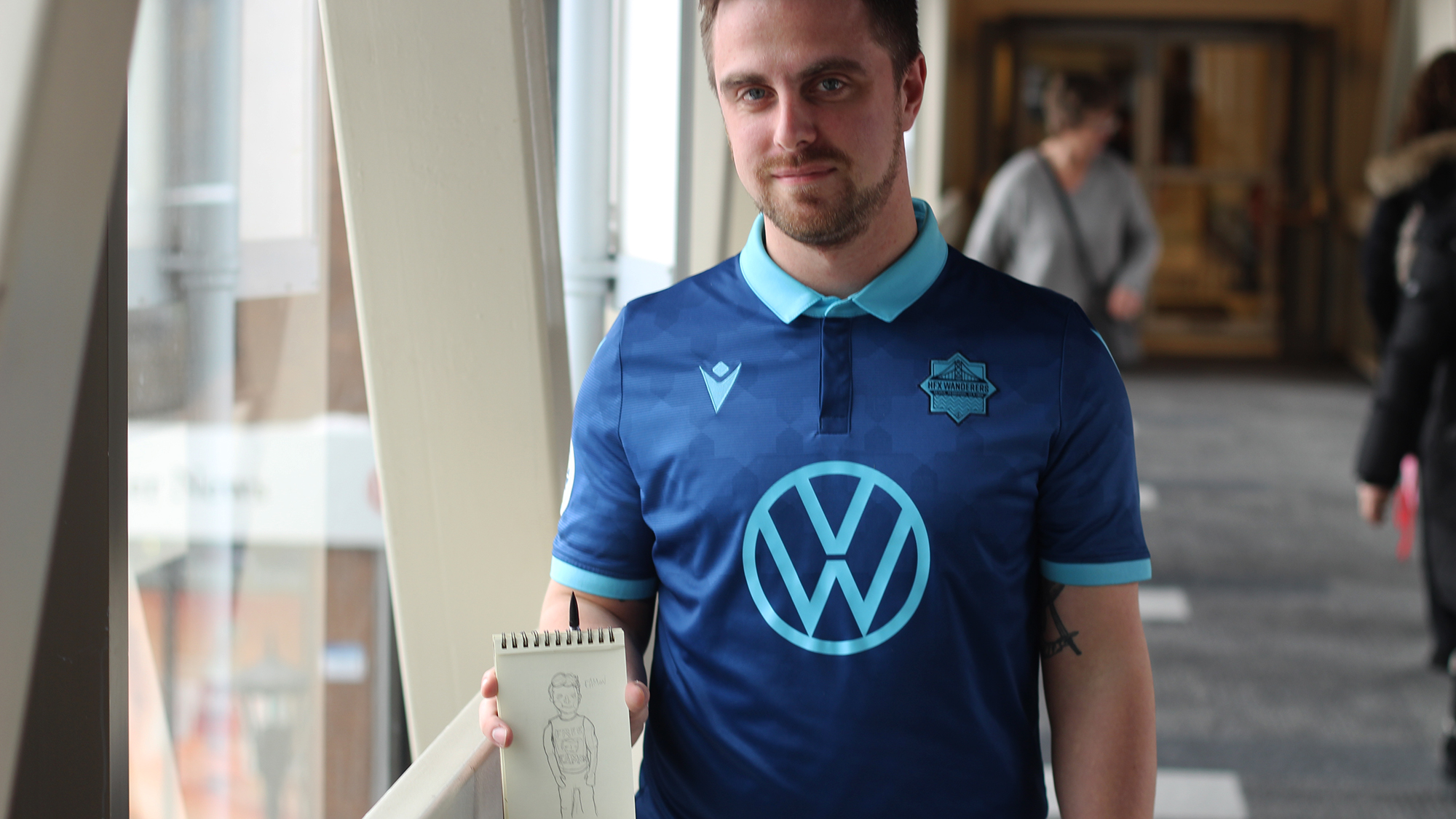 James Janssen poses with his sketchbook, where he's sketched some of the fans of the Wanderers. 