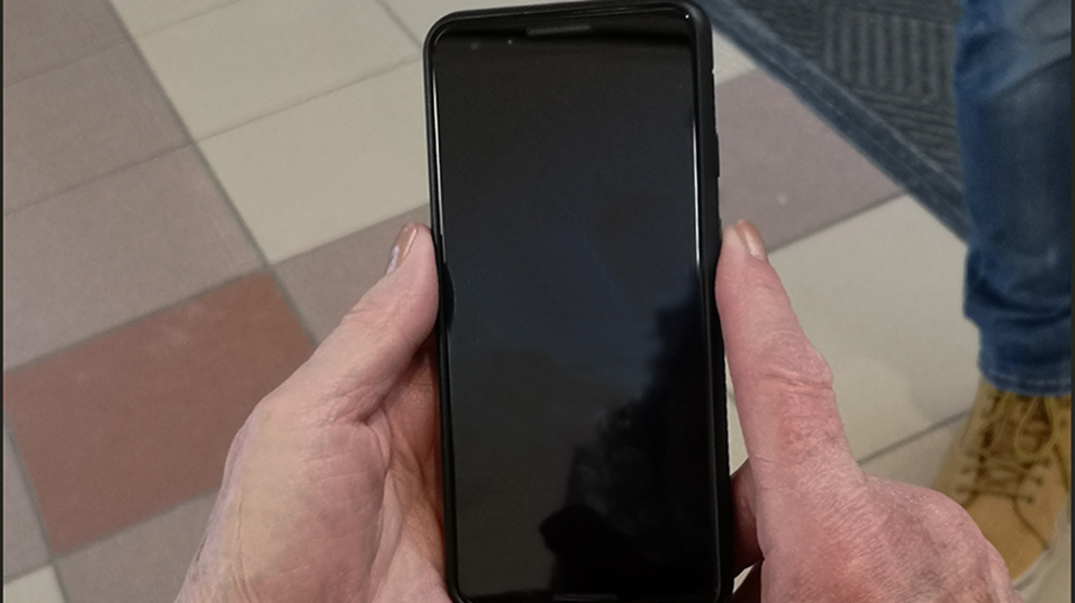 A senior holding a smartphone in Halifax.