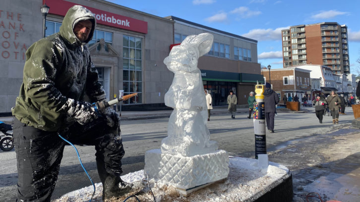 Ghislain Frigault poses with his ice sculpture seconds after completing it.