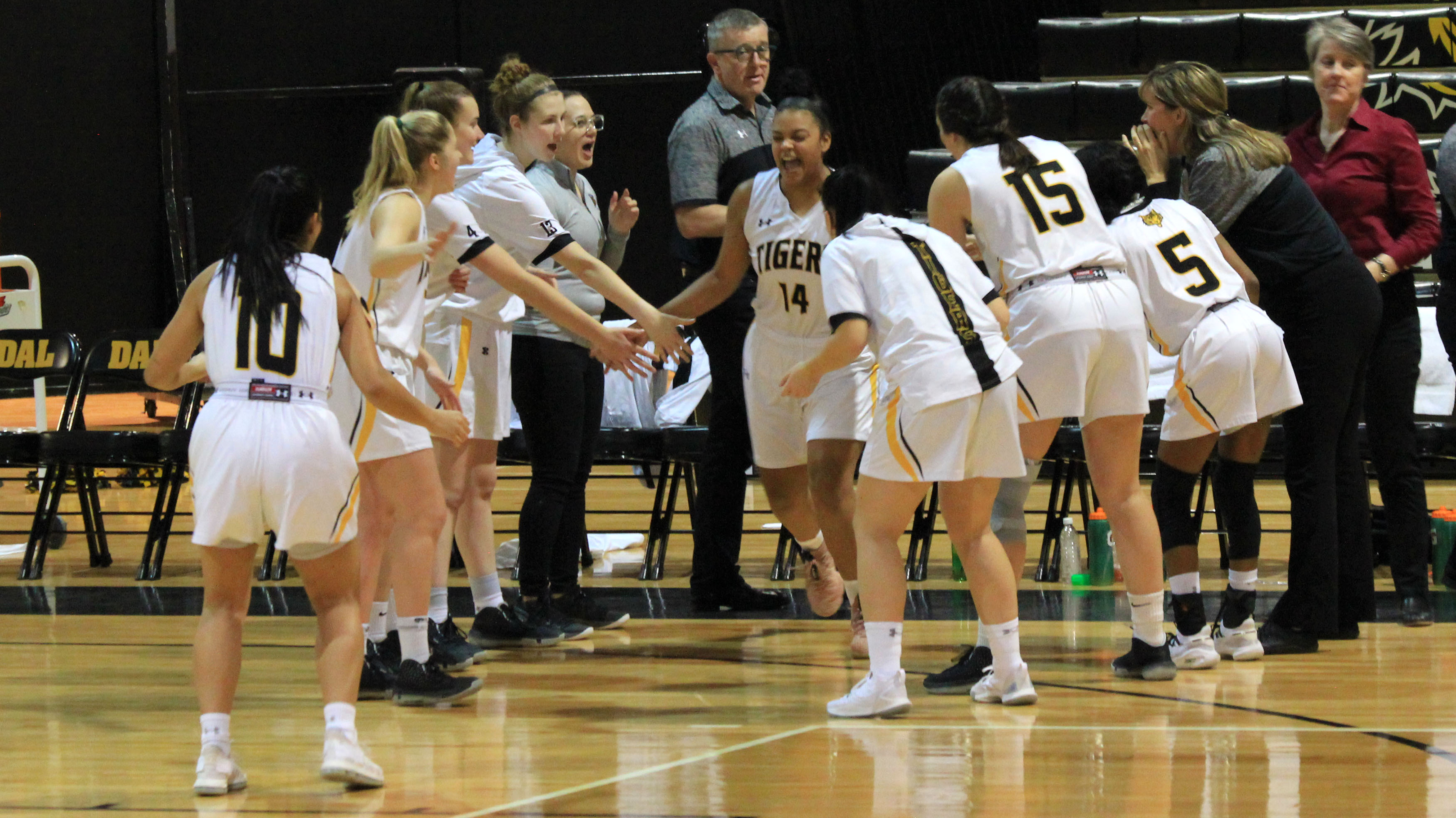 The Dalhousie women's basketball team cheers on the starting lineup as they step onto the court. 