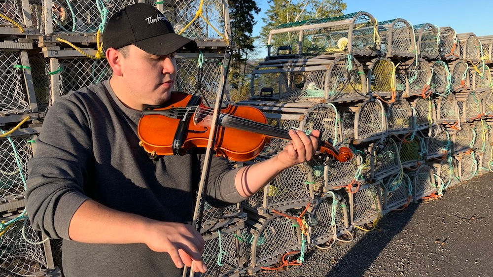Morgan Toney plays his fiddle at the wharf beside Wagmatcook Elders Centre in Wagmatcook First Nation, one of the two communities he calls home.