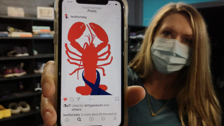 Anne Perry shows a sticker her children designed for an Instagram post. She created a colorectal cancer awareness Instagram page, TestForToby.