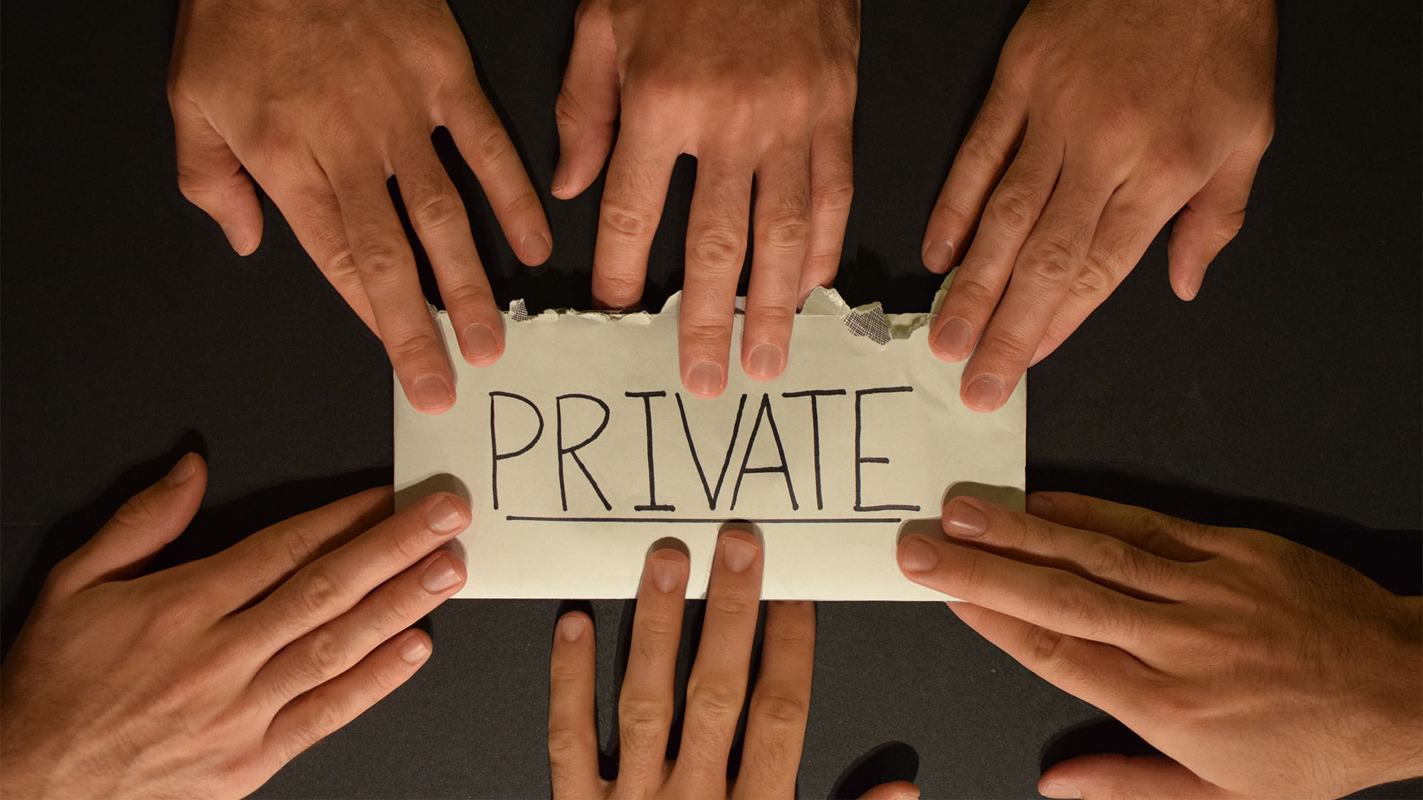 Hands grab at a private letter in this photo illustration.