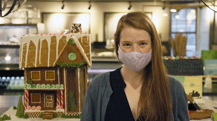 Katie MacLeod poses in front of her gingerbread house at The Old Apothecary Bakery and Café on Monday.