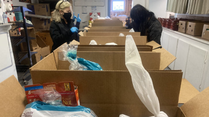 Volunteers pack food boxes at Parker Street Food and Furniture Bank. 