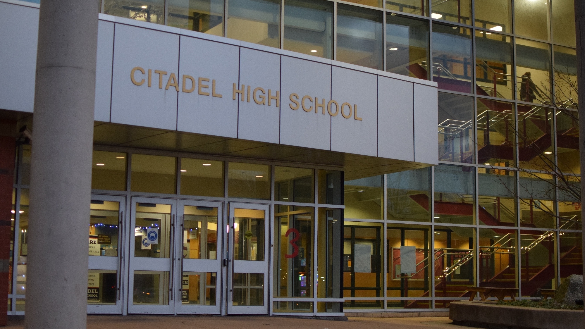 The front of a high school with the name Citadel High School written above the door.