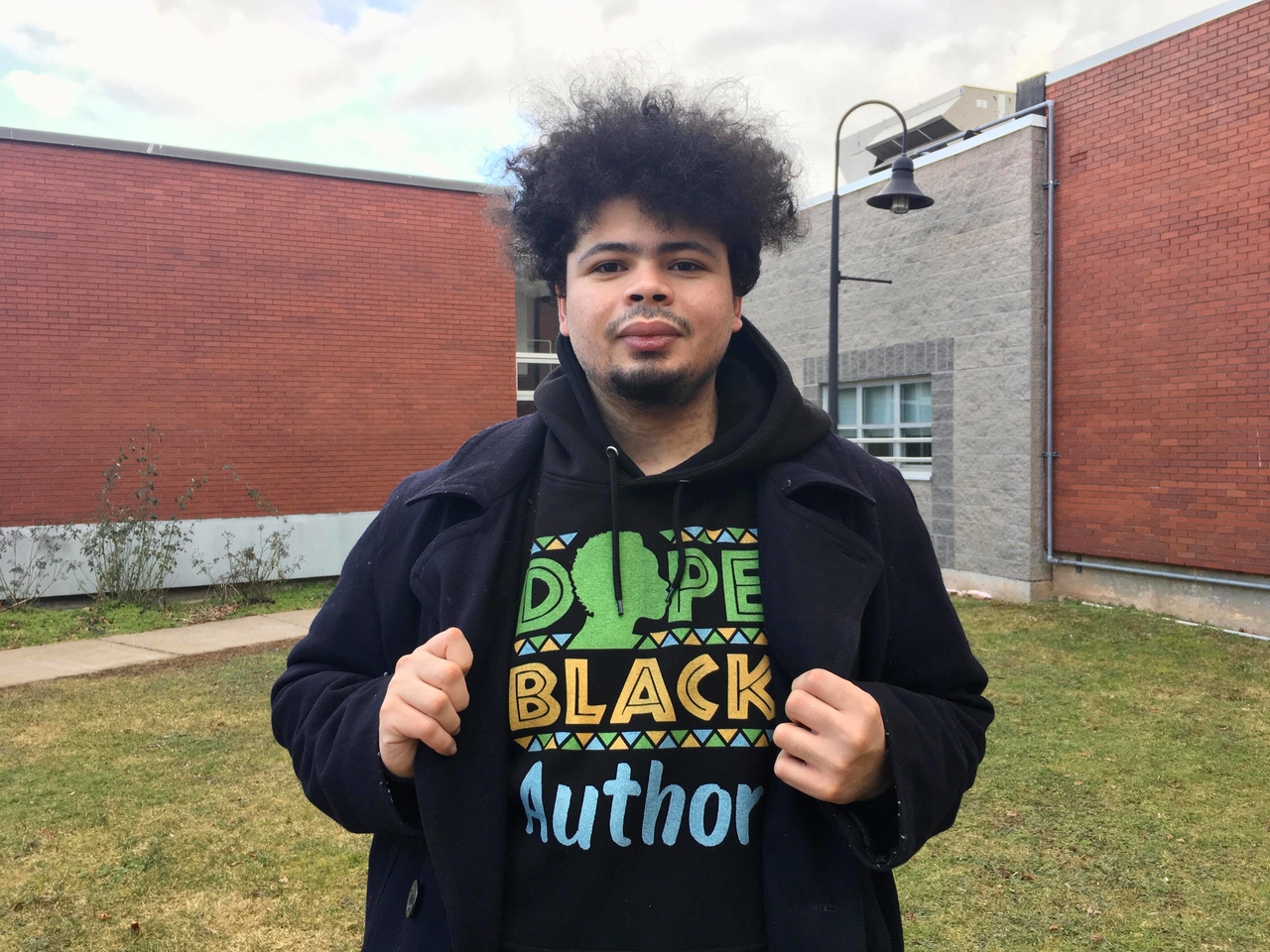 Andre Fenton wearing a hoodie that says "Dope Black Author"